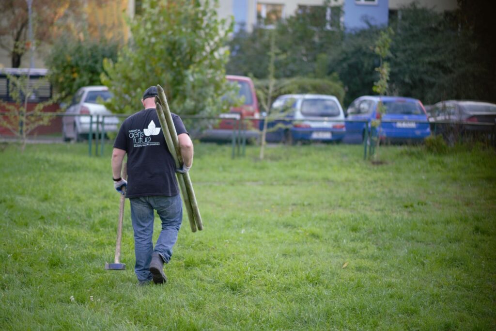 Pracownik fundacji przygotowujący się do sadzenia drzewa.