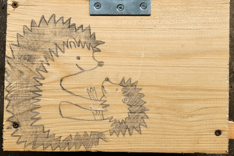 Na zdjęciu widoczne narysowane jeże na jednym z domków wykonanych podczas naszych warsztatów.